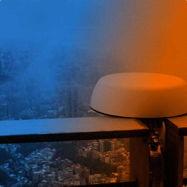 Pepwave antenna mounted on a railing overlooking a cityscape.